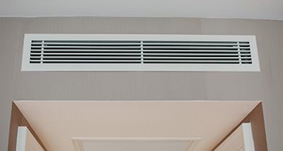 a ducted air conditioning vent on the top wall of a room
