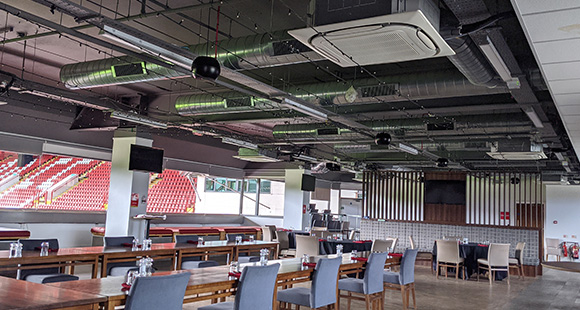 a cafeteria inside a stadium with a ceiling mounted air conditioning system installed above